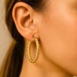 35mm 14k Yellow Gold Twisted Oval Hoop Earrings on Model
