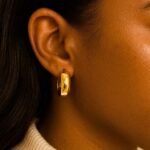 Medium Size 14k Yellow Gold Wide Hoop Earrings on Model Ear
