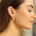 Model Wearing 14k Yellow Gold Large Tapered Hoop Earrings 20mm Model Wearing 14k Yellow Gold Large Tapered Hoop Earrings 20mm