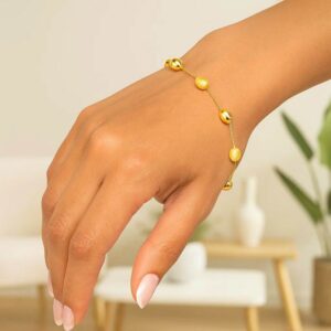 Real 14k Yellow Gold Pebble Bracelet with Textured and Polished Pebble Stations on model wrist