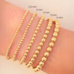 Model Wearing 2.5mm, 3mm, 4mm, 5mm and 6 mm 14K Yellow Gold Filled Elastic Bead Stackable Bracelet Sizes