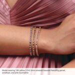 model wearing 14K Gold Bezel Set Emerald Cut Lab Grown Red Ruby Tennis Bracelet